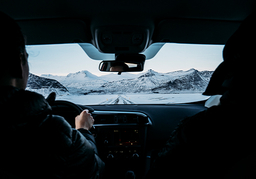 homem dentro do carro com vista para a montanha