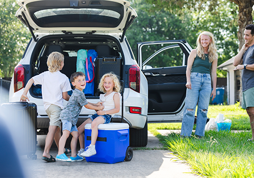 Parents and kids loading luggage into the car