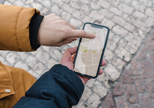 Two people pointing at GPS navigation on a smartphone