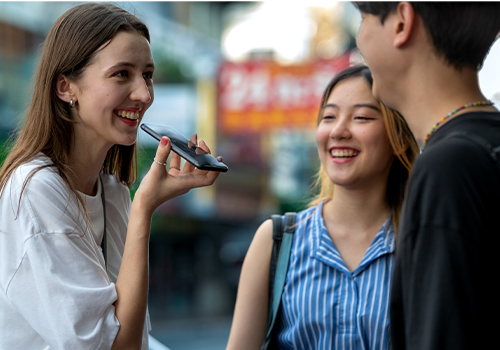Tourist using a phone translator app to speak with locals