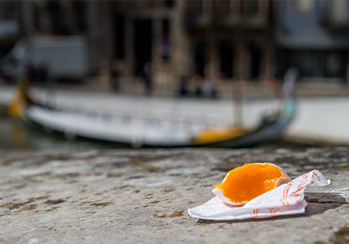 Ovos moles de Aveiro, doce tradicional, em cima de um murro com o canal de ria de fundo. 