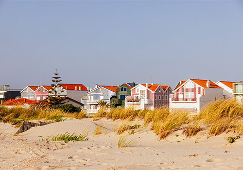 Casas coloridas às riscas na Costa Nova junto à praia, um dos locais mais emblemáticos para visitar em Aveiro.