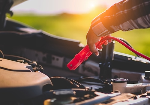 Cabos de bateria ligados entre dois carros para fazer arranque auxiliar.