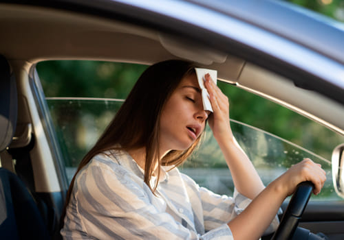 Woman feeling hot inside a car during a heatwave