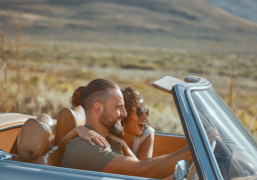 casal a viajar de carro nas férias