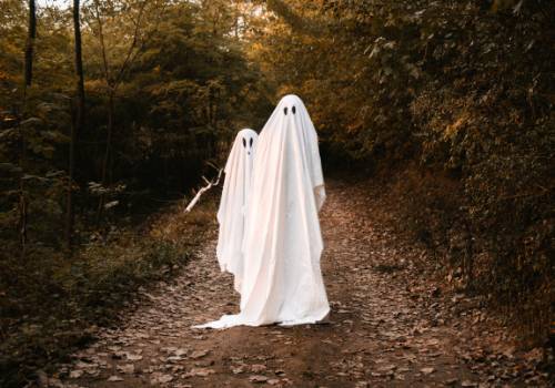 Two people dressed as ghosts on a road