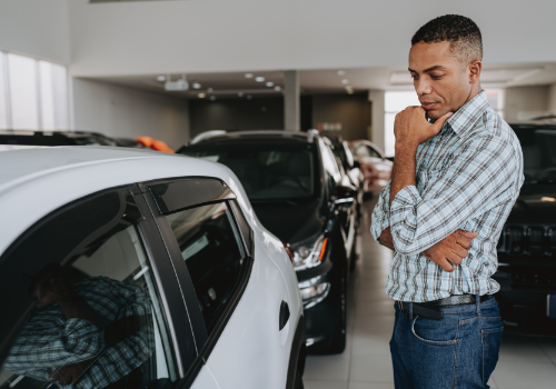 A man at a car dealership looking to buy a used car