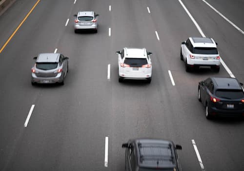 Condutora ajusta o retrovisor antes de iniciar uma condução defensiva.