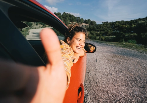 Jovem a viajar de carro durante um gap year, a desfrutar da liberdade da estrada.
