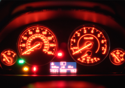 Luzes de aviso vermelhas e amarelas acesas no painel do carro.