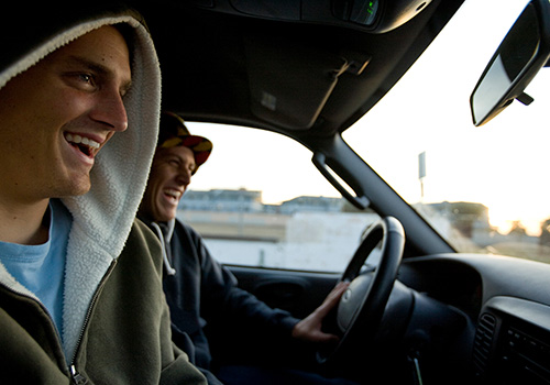 Two friends laughing inside a car