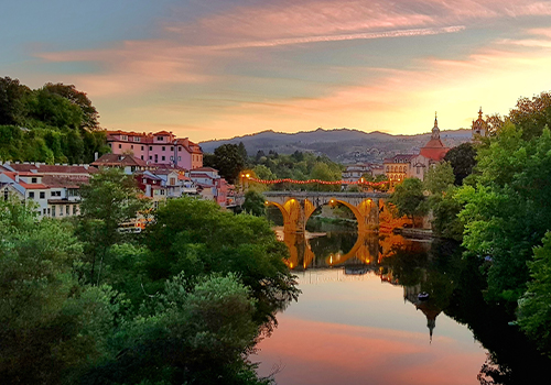 Vista panorâmica da cidade de Amarante ao pôr do sol, com a ponte histórica sobre o rio Tâmega, um destino encantador para descobrir no verão em Portugal.