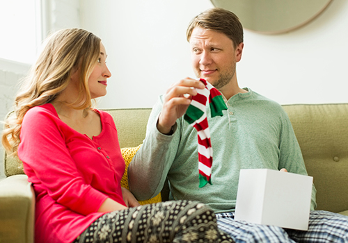 Homem a segurar meias com ar desconfortável