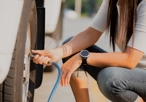 Woman checking tyre pressure