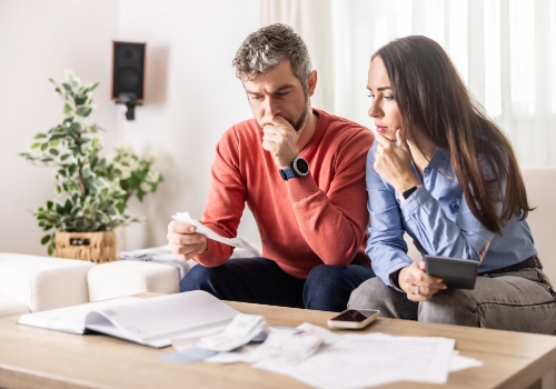 Casal a analisar documentos e despesas do seguro automóvel.