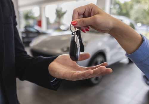 Vendedora de carros a dar chaves de carro a um senhor