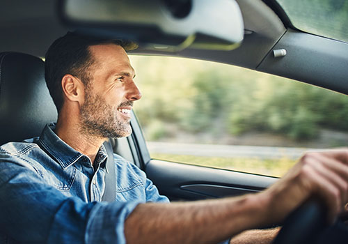 man smiling while driving.